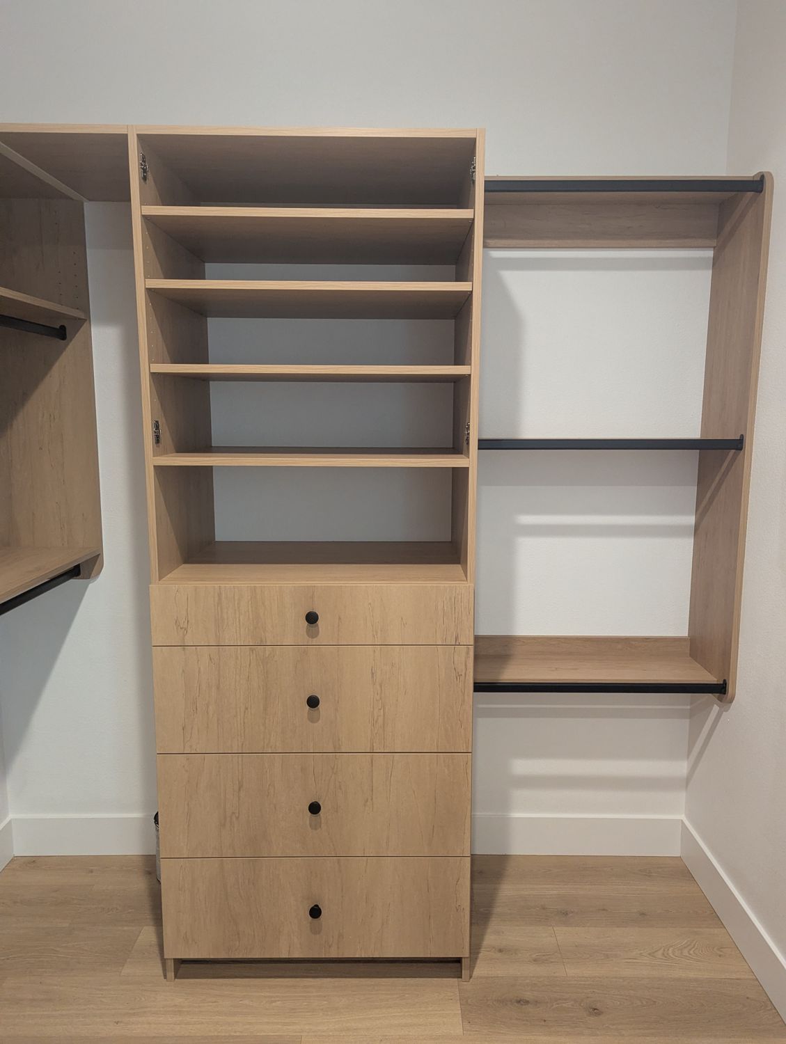 Wood grain closet with tall shelf stack and a four-drawer tower